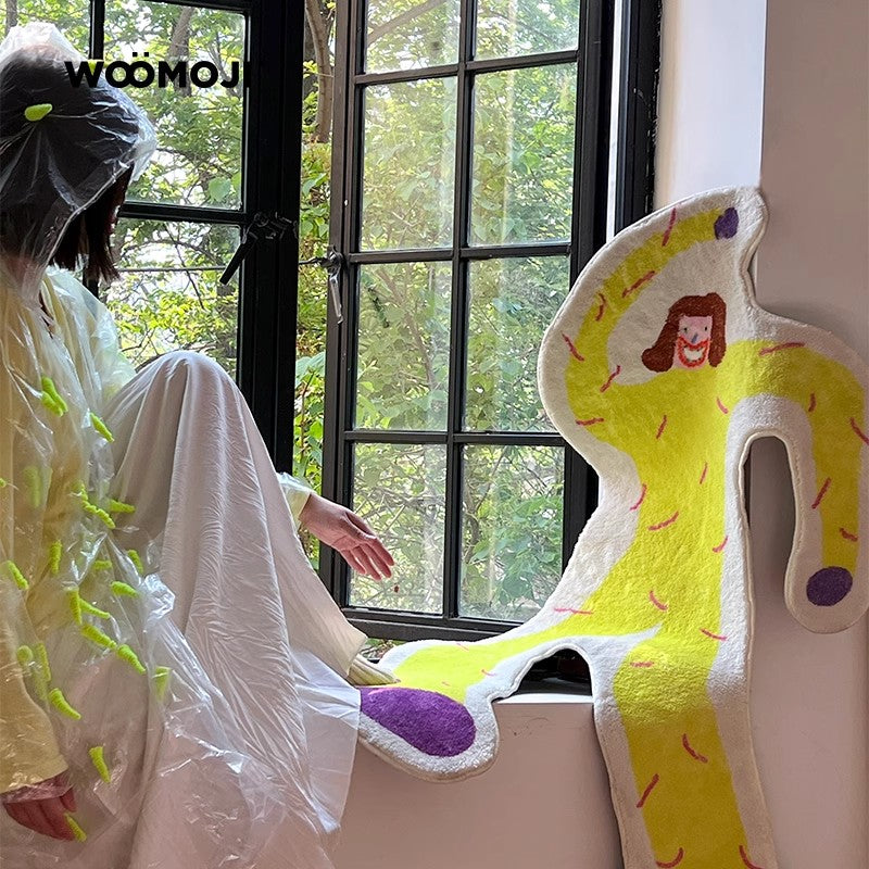 Person in a white outfit with green accents sitting by a window, looking at a colorful plush toy.